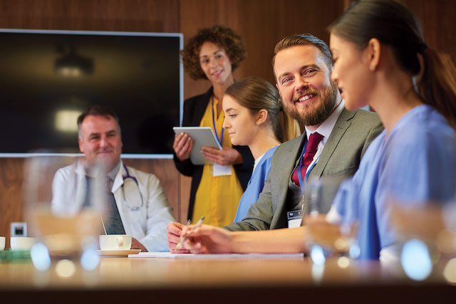 Managers and clinicians meeting in a board room