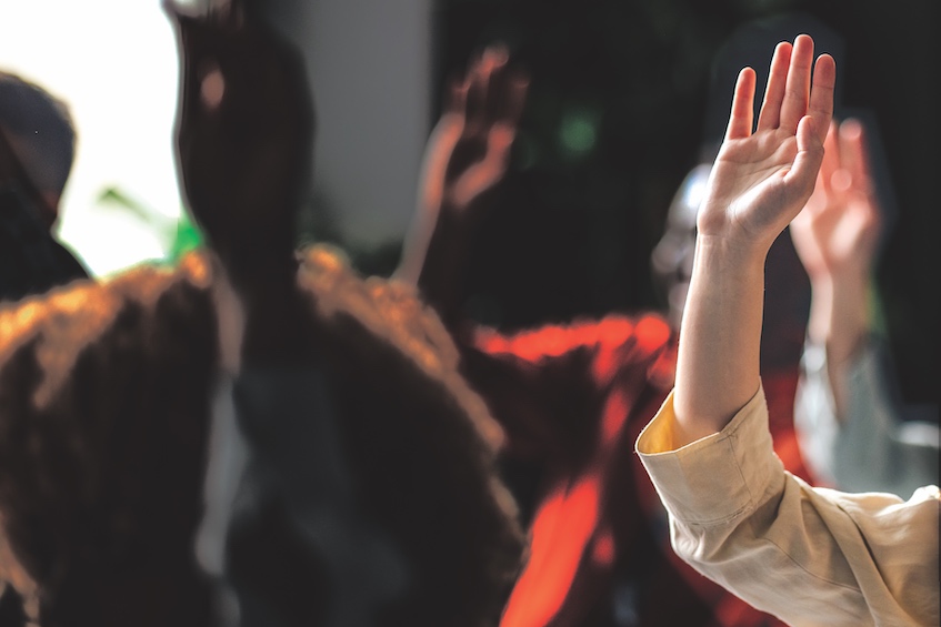 Blurred picture of raised hands in a meeting