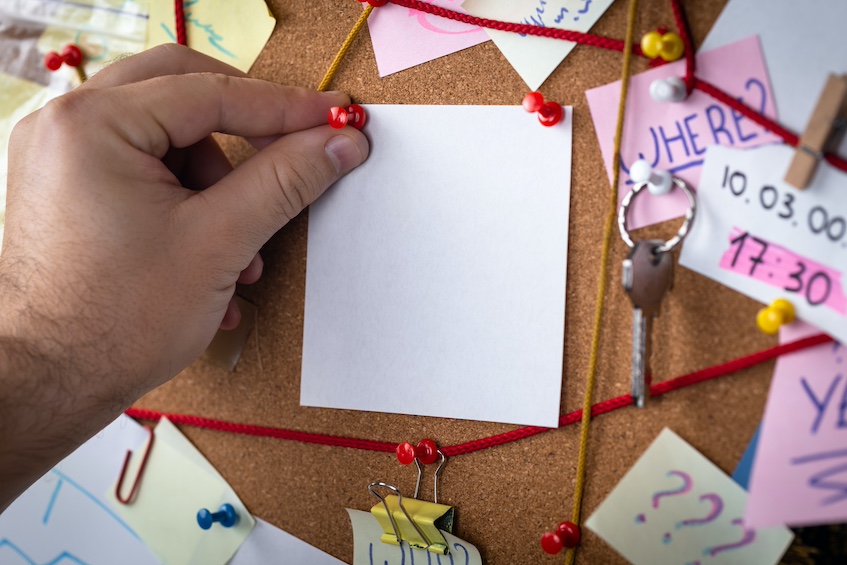 Man pinning note to investigation board