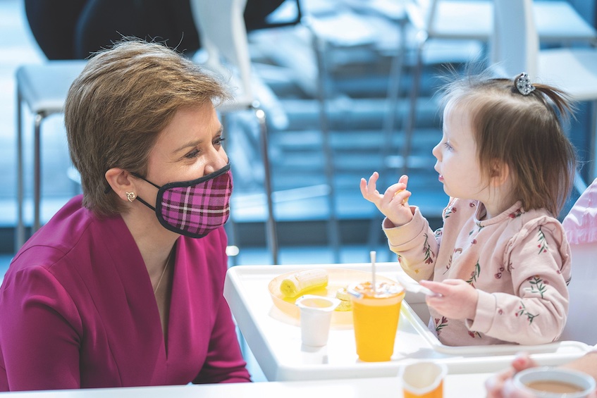 Nicola Sturgeon with child - Scotland plans for National Care Service