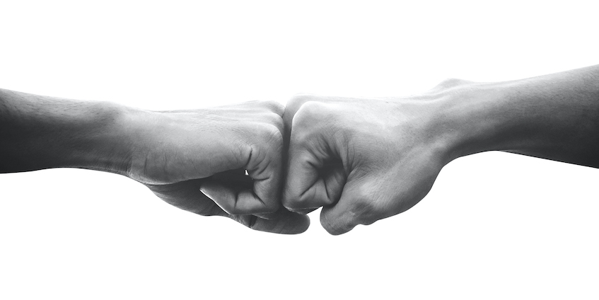 Black and white allies fist bump