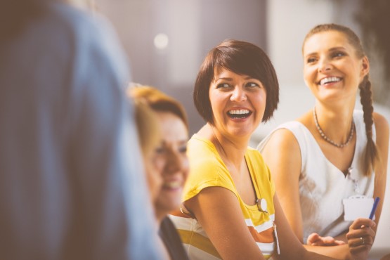 Group of women smiling at a meeting