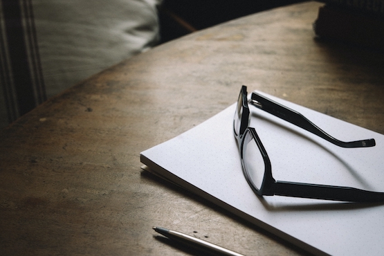 glasses on notepad in darkened room